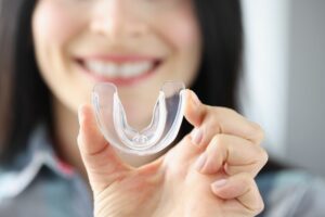 woman holding clear mouth guard